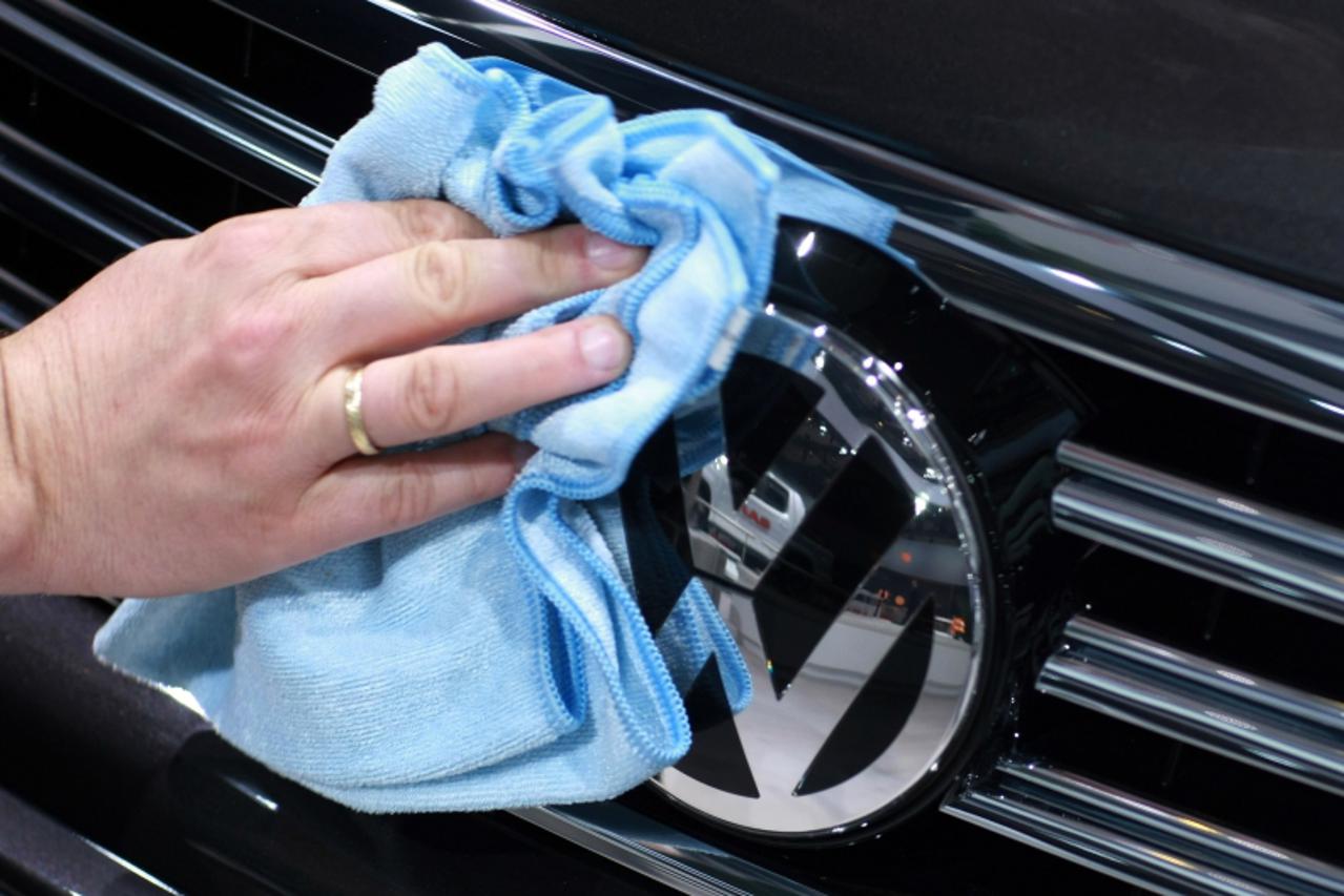 \'A worker polishes the logo on a Volkswagen car during the company\'s annual general meeting in the northern German city of Hamburg on April 23, 2009. Directors of VW, the biggest European car maker,