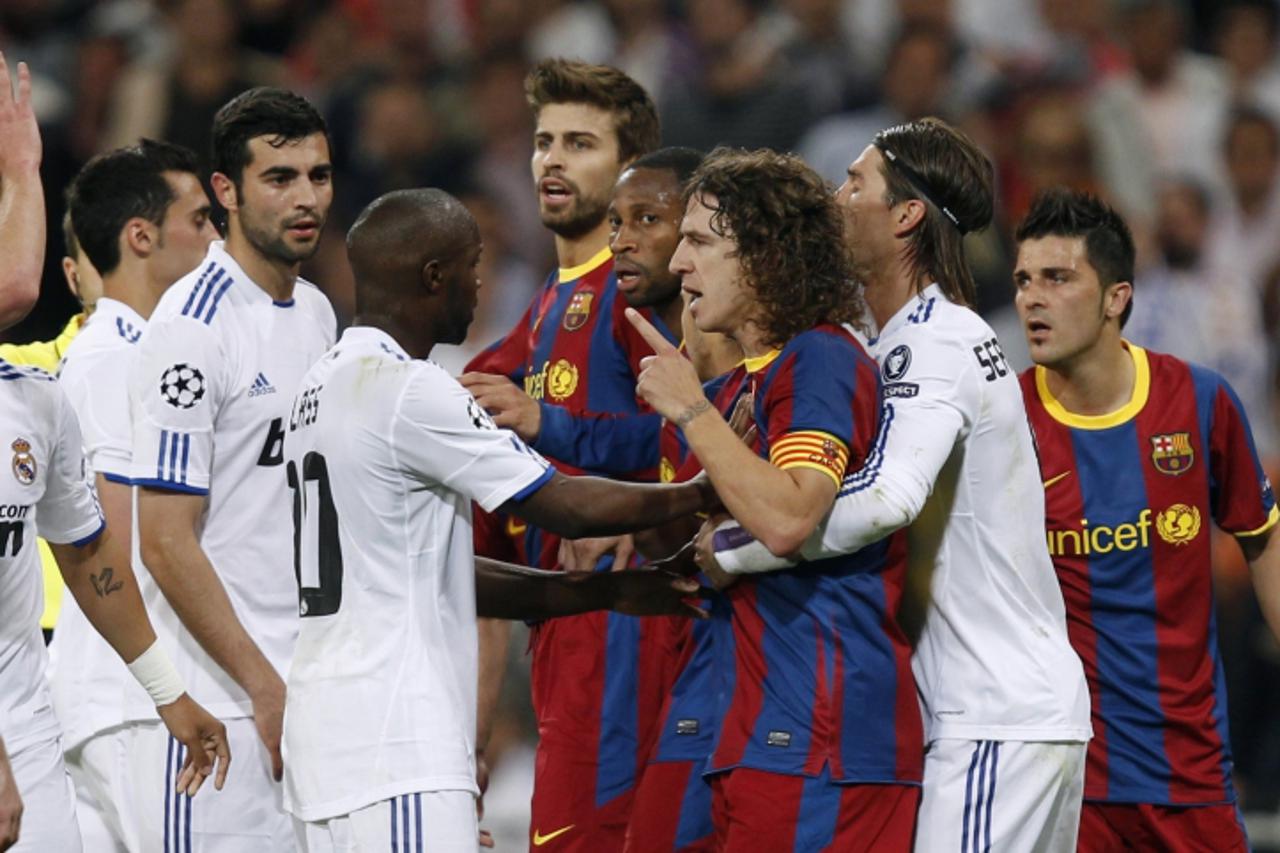'Real Madrid\'s players and Lassana Diarra (C) react against Barcelona\'s players and captain Carles Puyol (3rd R) during their Champions League semi-final first leg soccer match at Santiago Bernabeu 