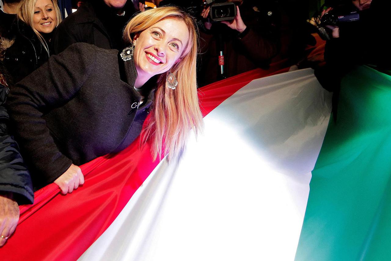 FILE PHOTO: Fratelli D'Italia party leader Giorgia Meloni poses next to an Italian national flag during an electoral rally in Rome