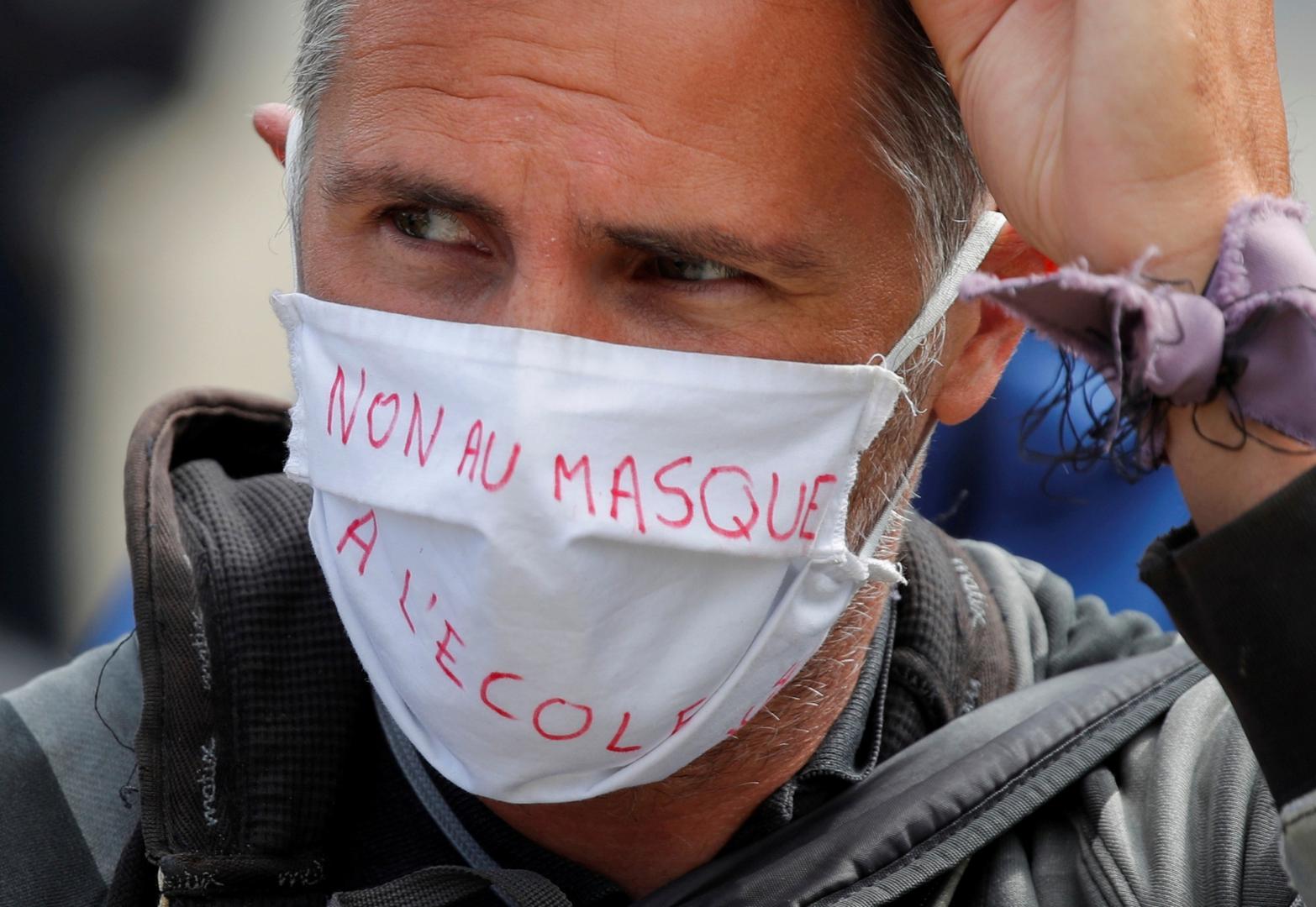 Protest against the coronavirus disease (COVID-19) restrictions in Paris A protester wears a protective face mask which reads " No mask at school" during a demonstration against the coronavirus disease (COVID-19) restrictions, in Paris, France, August 29, 2020. REUTERS/Charles Platiau CHARLES PLATIAU