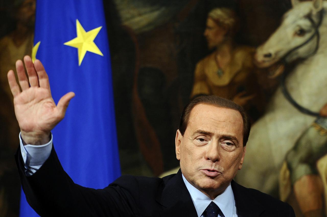 'Italian Prime Minister Silvio Berlusconi waves during a joint press conference with European Union commission President Jose Manuel Barroso (not pictured) following their meeting on March 14, 2011 at