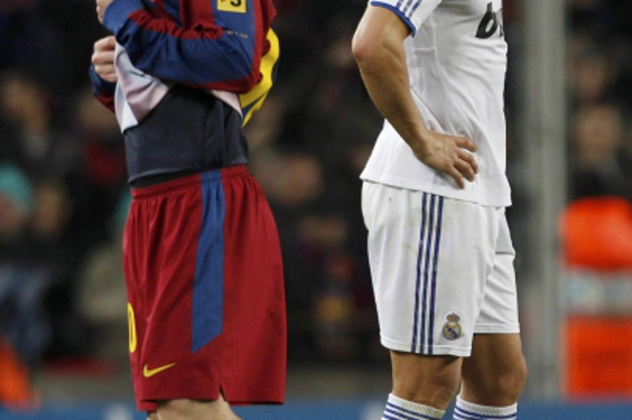 'Real Madrid\'s Cristiano Ronaldo (R) and Barcelona\'s Lionel Messi react during their Spanish first division soccer match at Nou Camp stadium in Barcelona, November 29, 2010. REUTERS/Albert Gea (SPAI