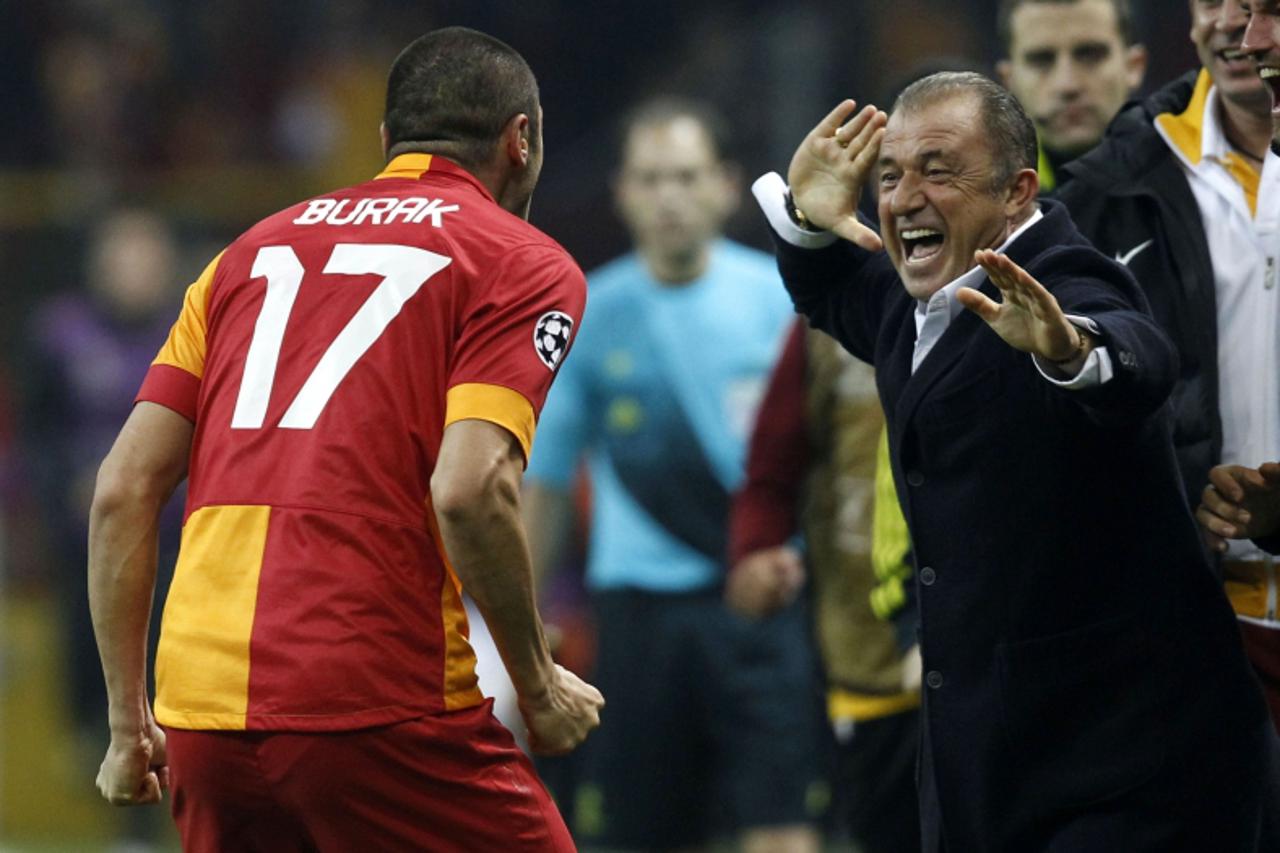 'Galatasaray's Burak Yilmaz celebrates with his coach Fatih Terim (R) after their goal against Manchester United during their Champions League Group H soccer match at Turk Telekom Arena in Istanbul N