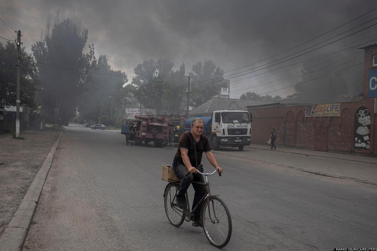 A man rides a bicycle along a street at the market after shelling in Sloviansk