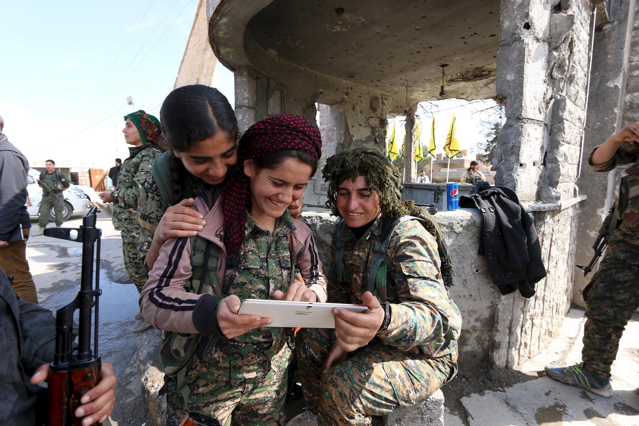 Female fighters from the Democratic Forces of Syria use a tablet in al-Shadadi town, in Hasaka province, Syria February 26, 2016. REUTERS/Rodi Said