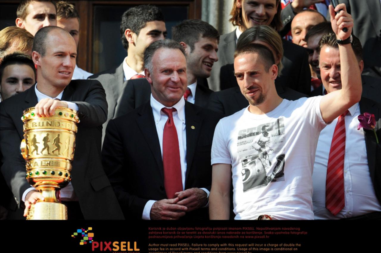 'Bayern\'s Arjen Robben (front L-R), CEO Karl-Heinz Rummenigge and Franck Ribery pictured with the German DFB Cup trophy on the balcony of the town hall in Munich, Germany, 23 May 2010. Despite the de