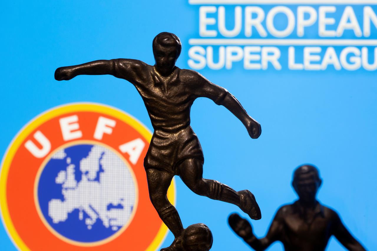 FILE PHOTO: Metal figures of football players are seen in front of the words "European Super League" and the UEFA logo in this illustration