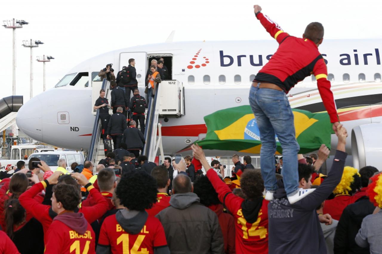 'Belgium's soccer team players board a Brussels Airlines plane as supporters of the national squad gather on the tarmac of Brussels' international airport October 9, 2013. Belgium will play against 