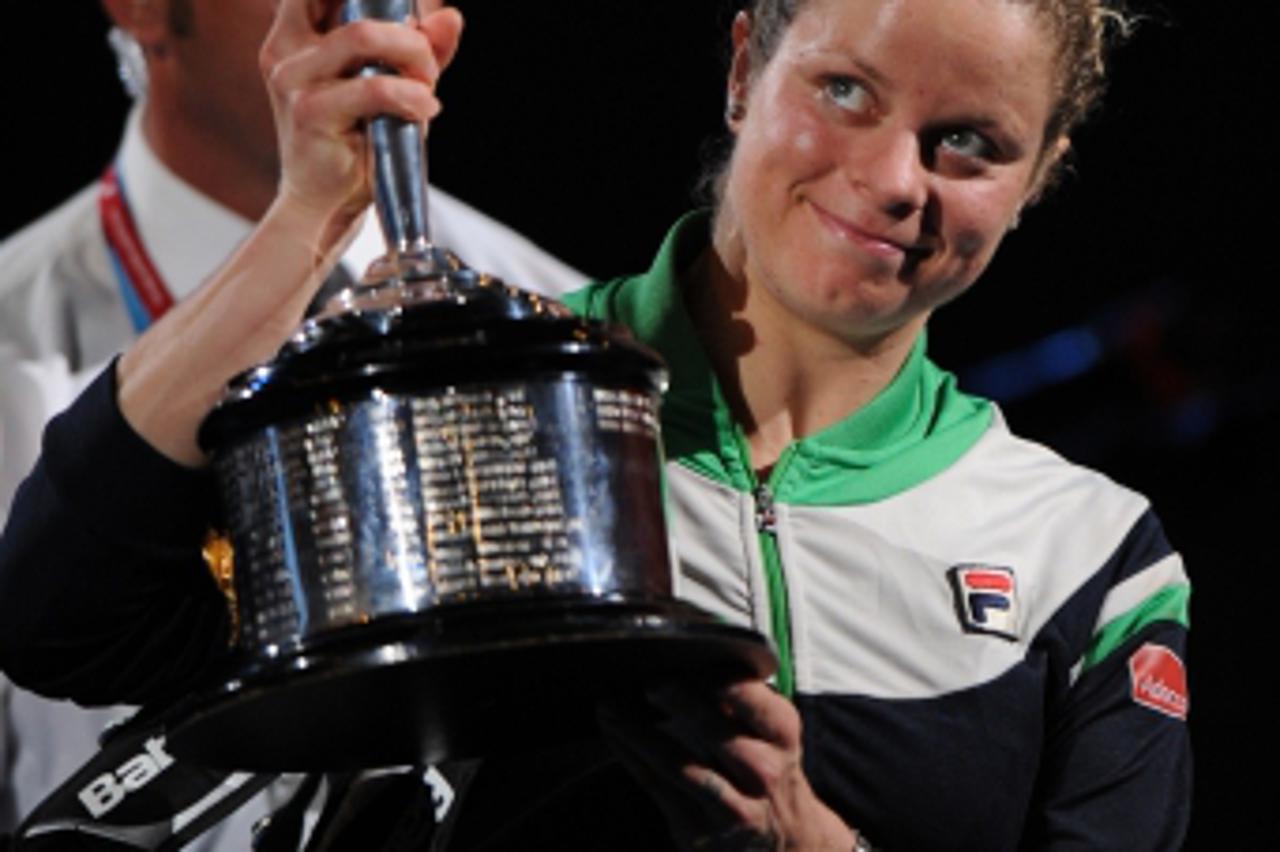 \'Kim Clijsters of Belgium poses with the winner\'s trophy after beating runner-up Li Na of China in the women\'s singles final on the thirteenth day of the Australian Open tennis tournament in Melbou