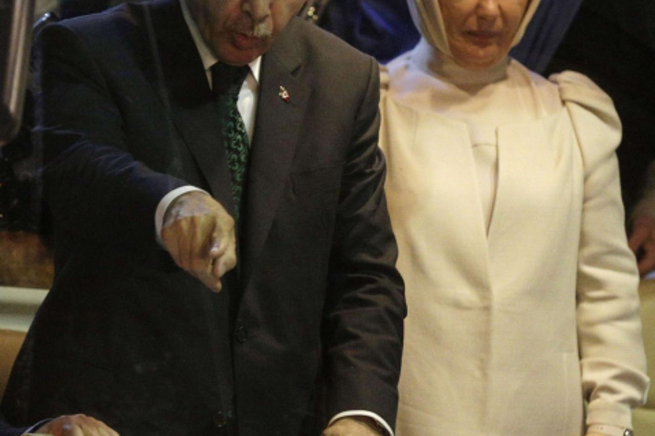 'Turkey's Prime Minister Tayyip Erdogan (L) points to supporters next to his wife Emine after arriving at Istanbul's Ataturk airport early June 7, 2013. Erdogan called on Turks on Friday to distance