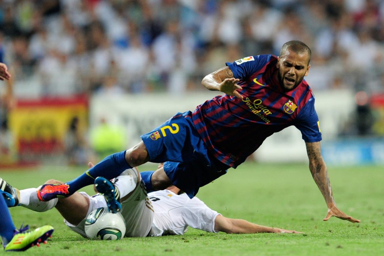 'Barcelona\'s Brazilian defender Dani Alves (up) vies for the ball with Real Madrid\'s midfielder Xabi Alonso during the first leg of the Spanish Supercup football match Real Madrid against Barcelona 