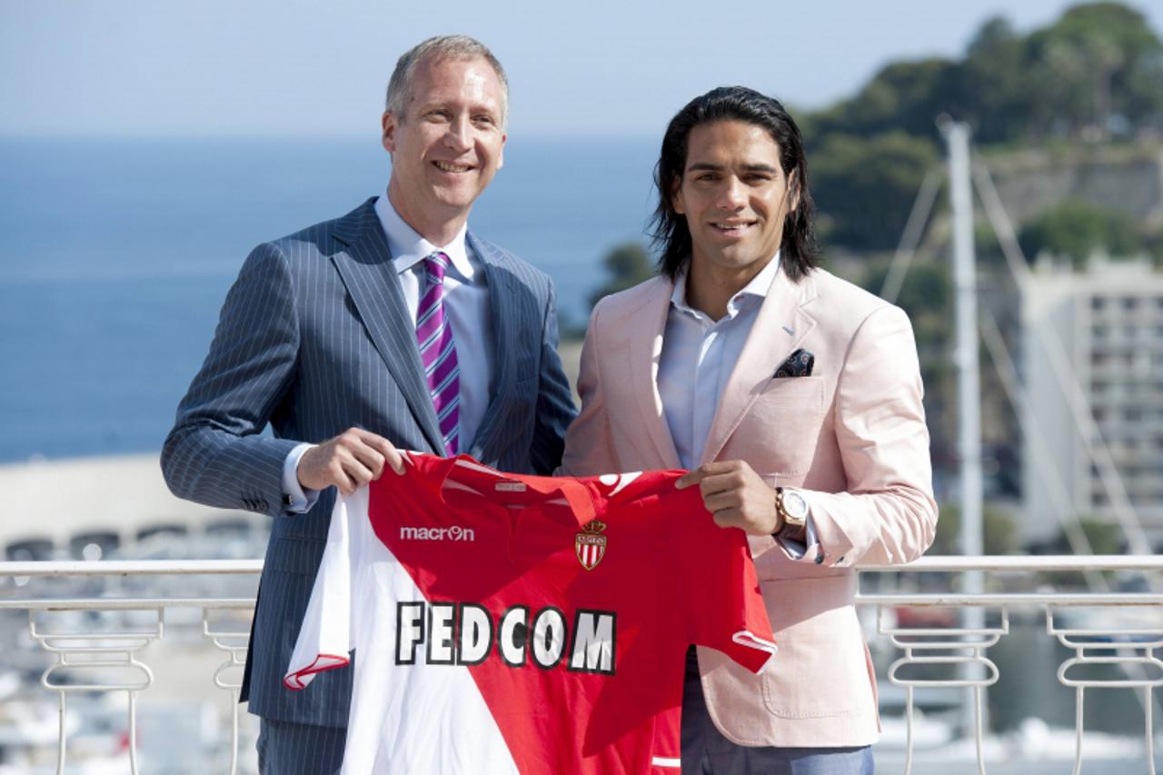 'AS Monaco sports director Vadim Vasilyev (L) and Colombian striker Radamel Falcao, newly-signed player for the French Ligue 1 soccer club, pose holding the new jersey after a news conference in Monac