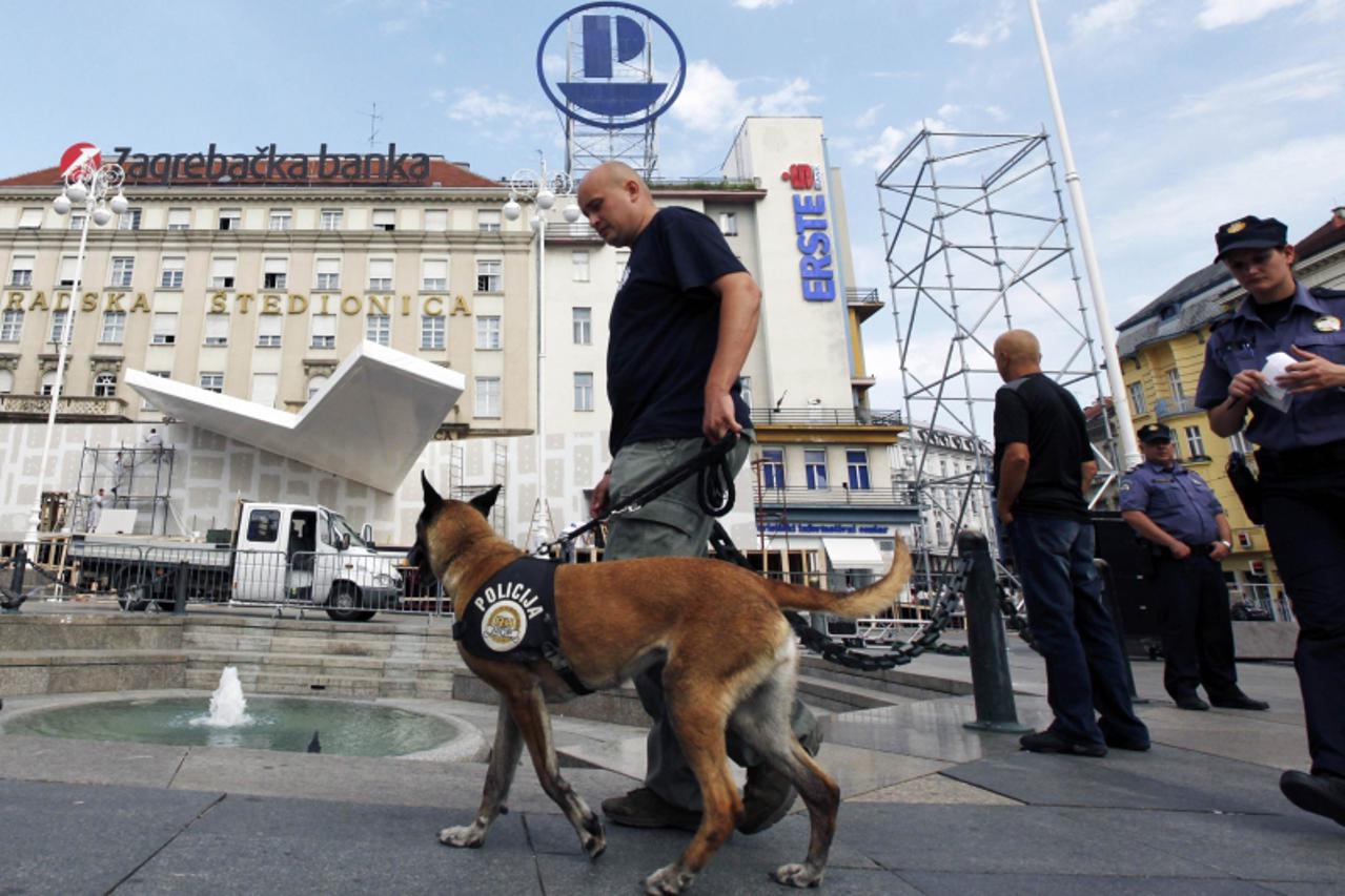 \'A police explosive specialist and his dog patrol Zagreb\'s main square, while workers construct a stage ahead of Pope Benedict XVI\'s visit, June 1, 2011. The Pope will visit Zagreb for the first ti