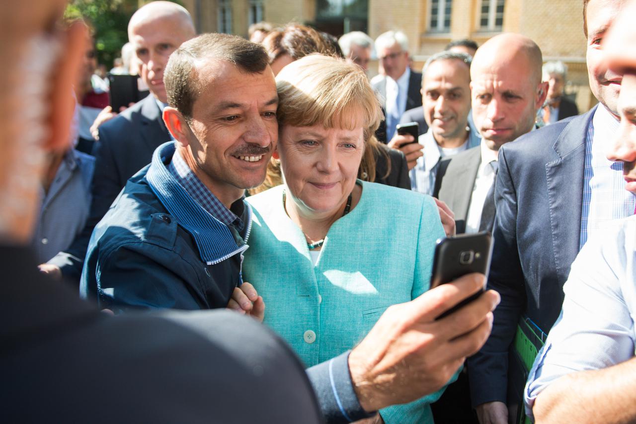 German Chancellor Angela Merkel  (CDU, R) is having pictures taken with  refugees at the reception centre for asylm seekers, joint effort of the Federal Office for Migration and Refugees and the  'Arbeiterwohlfahrt (AWO)',  Workers Welfare Federal Associa