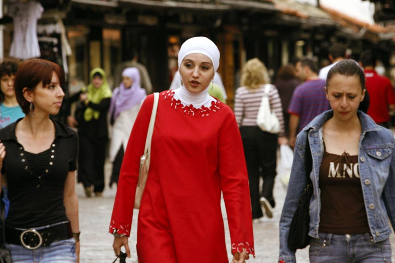 'TO GO WITH AFP STORY BOSNIA-RELIGION-ISLAM-HEADSCARF BY Rusmir Smajilhodzic  A veiled Bosnian Muslim woman (C) walks with two other young women in downtown Sarajevo, 17 May, 2007. After being banned 