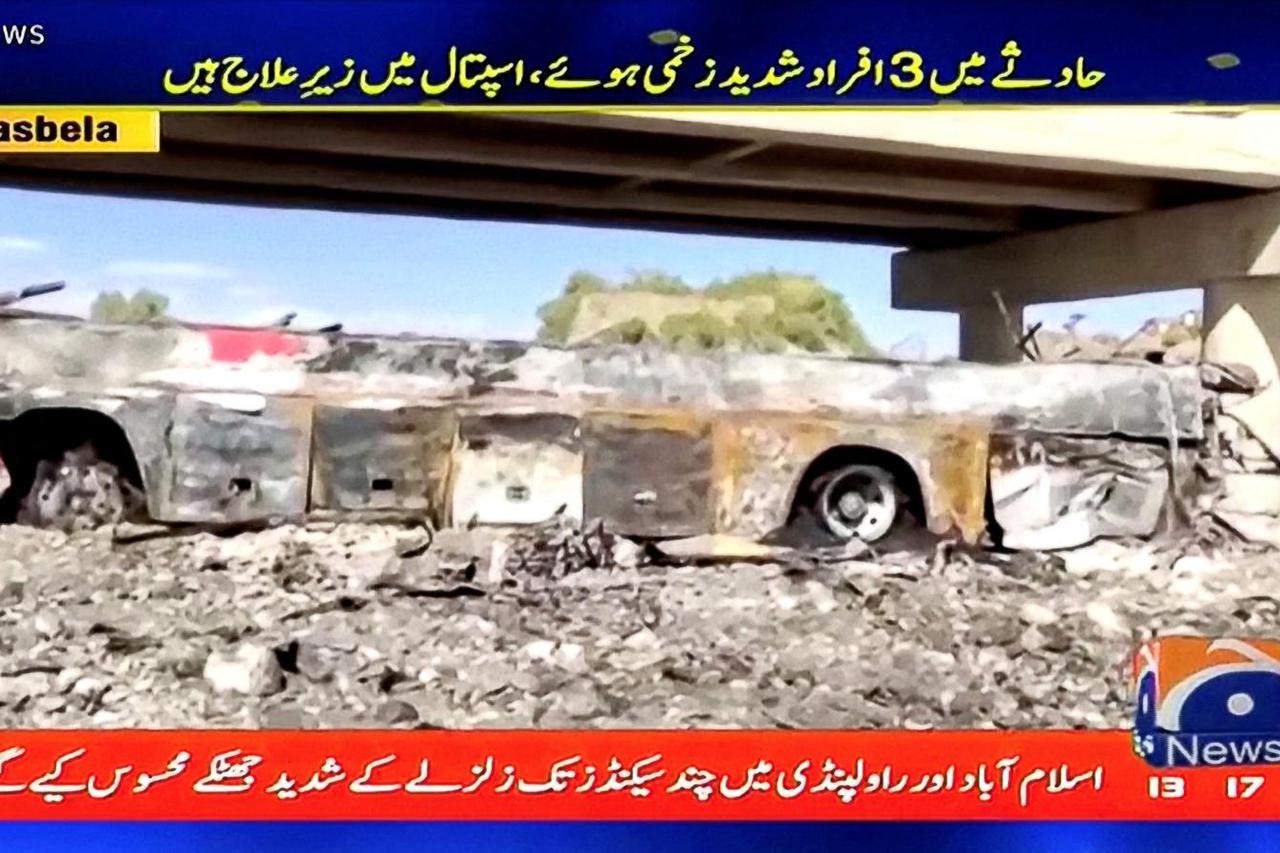 A screen grab shows the wreckage of a bus after a crash in Lasbela District