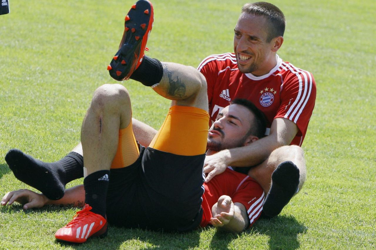 'Bayern Munich's Franck Ribery (top) jokes with Diego Contento during a training session in Arco, northern Italy July 5, 2013. REUTERS/Alessandro Garofalo (ITALY - Tags: SPORT SOCCER)'