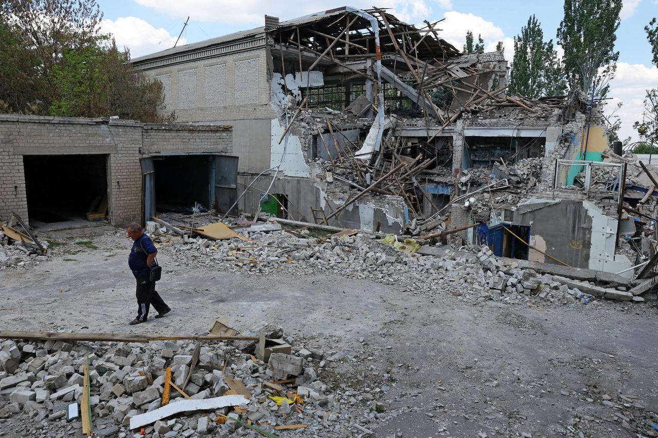 FILE PHOTO: A local resident walks past a destroyed building in Lysychansk