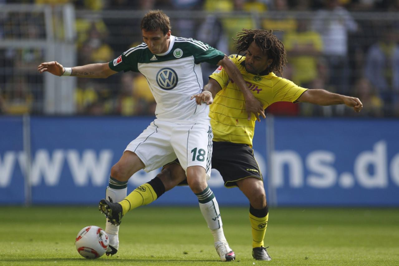 \'Borussia Dortmund\'s Patrick Owomoyela tackles Wolfsburg\'s Mario Mandzukic (L) during the German Bundesliga soccer match in Dortmund, September 11, 2010. REUTERS/Ina Fassbender (GERMANY - Tags: SPO