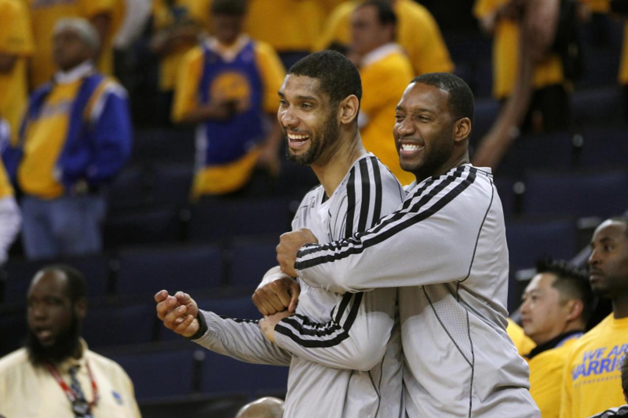 'San Antonio Spurs' Tracy McGrady (R) and Tim Duncan react in the closing moments of their win over the Golden State Warriors during Game 6 of their NBA Western Conference semi final playoff basketba