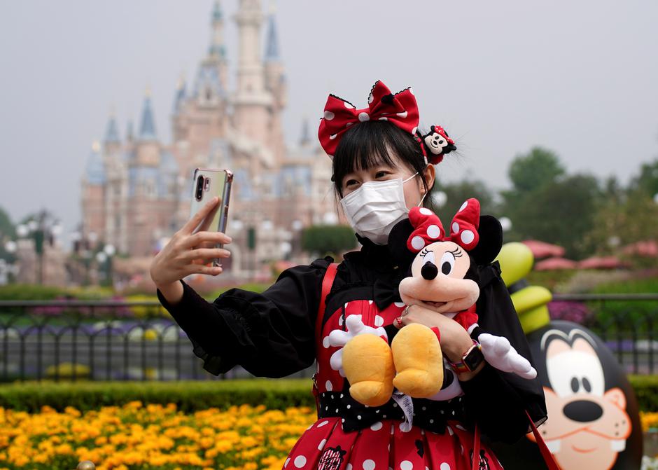 A visitor dressed as a Disney character takes a selfie while wearing a protective face mask at Shanghai Disney Resort as the Shanghai Disneyland theme park reopens following a shutdown due to the coronavirus disease (COVID-19) outbreak, in Shanghai