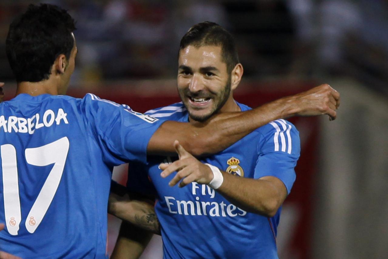 'Real Madrid\'s Karim Benzema (R) celebrates with teammate Alvaro Arbeloa after scoring a goal against Granada during their Spanish first division soccer match at Los Carmenes stadium in Granada Augus
