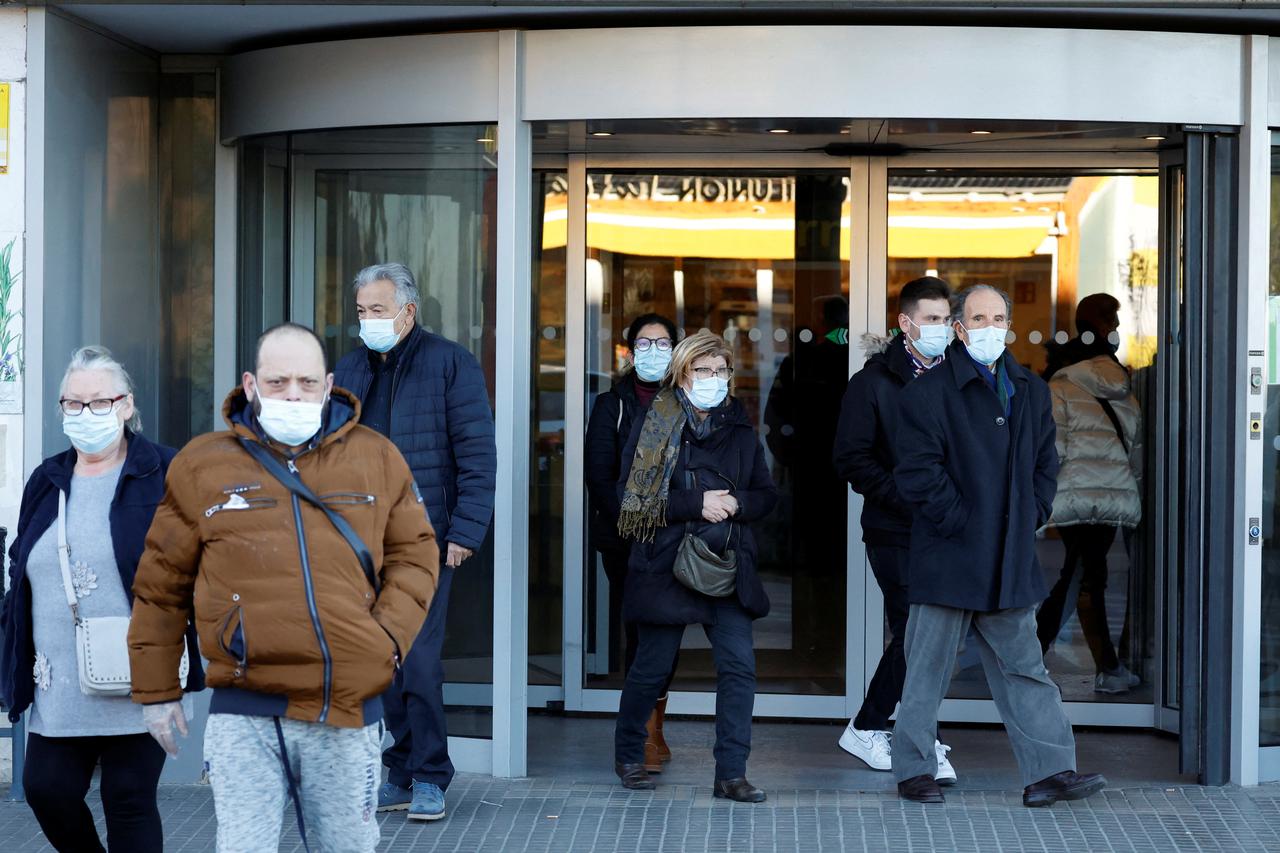 People wearing protective masks leave Germans Trias i Pujol Hospital in Badalona