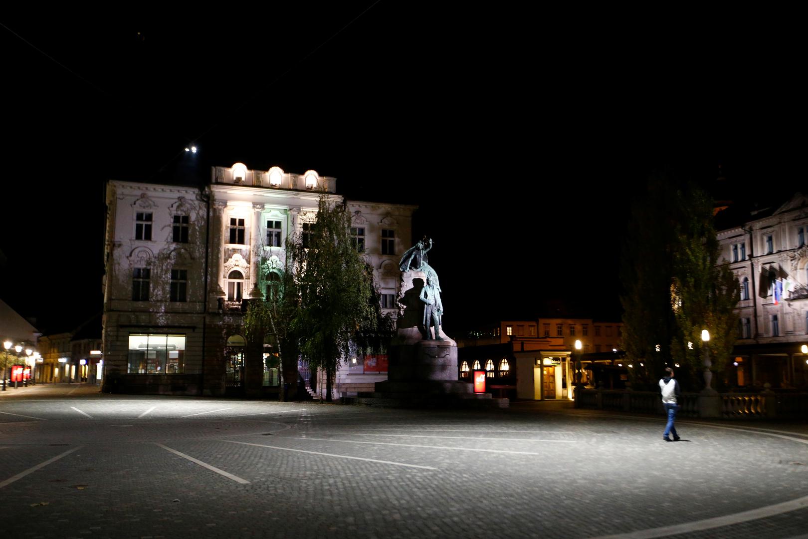 Slovenia starts a nightly curfew from 9 p.m. to 6 a.m as to curb the rising of the coronavirus disease (COVID-19) cases in the country, in Ljubljana A person walks in an almost empty area of the city as Slovenia starts a nightly curfew from 9 p.m. to 6 a.m as part of a state of emergency called to curb the rising of the coronavirus disease (COVID-19) cases in the country, in Ljubljana, Slovenia, October 20, 2020. REUTERS/Borut Zivulovic BORUT ZIVULOVIC