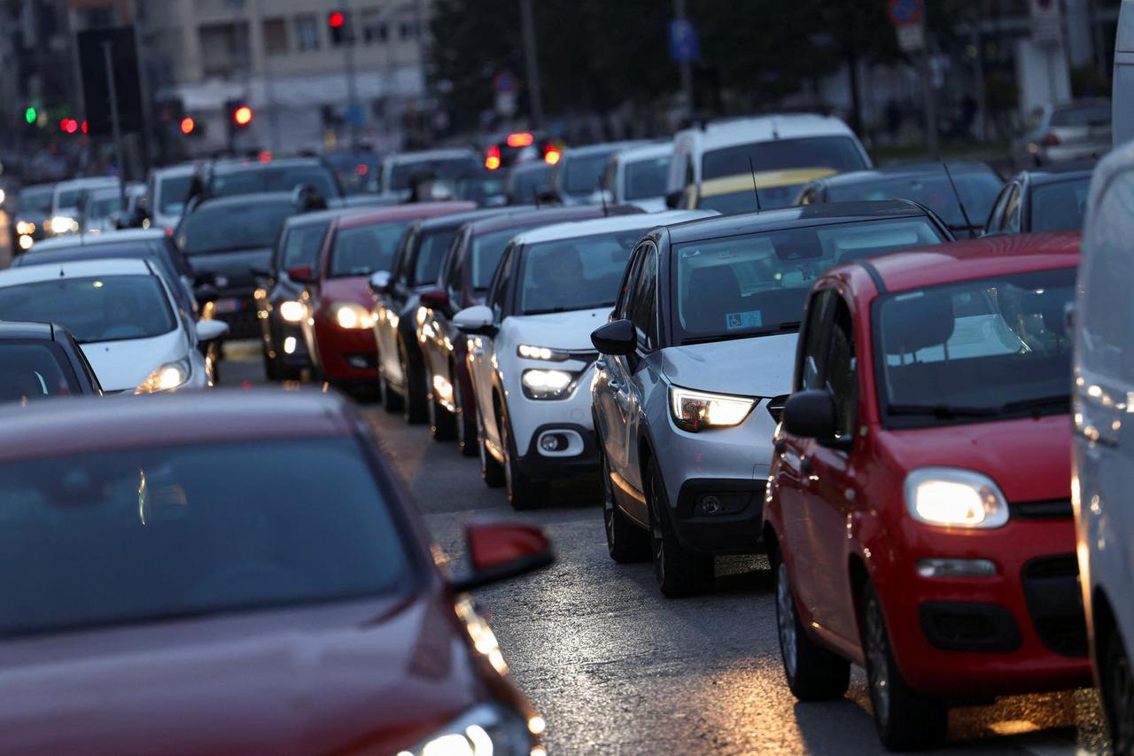 Cars wait in traffic on a road in central Milan