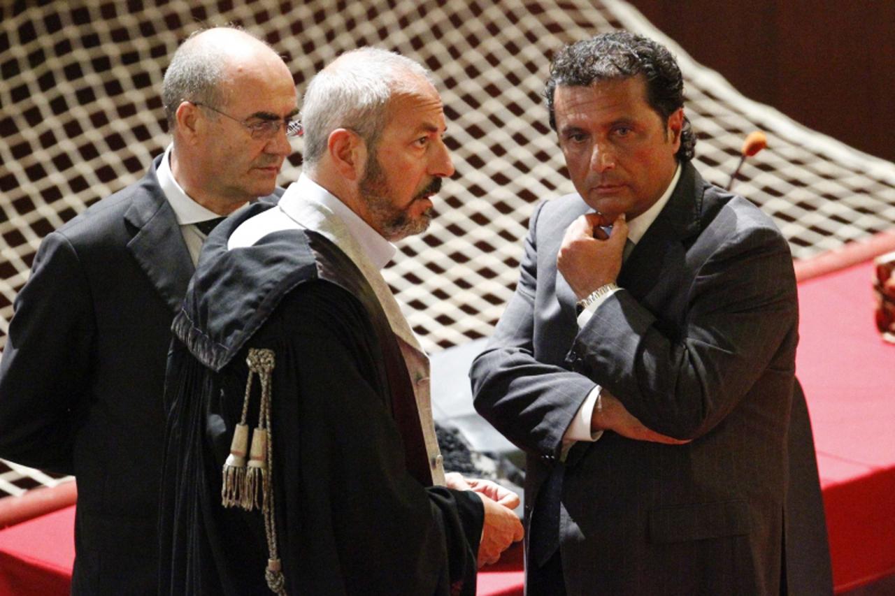 'Francesco Schettino (R), captain of the Costa Concordia cruise ship, talks with his lawyers during a trial in Grosseto, central Italy, July 17, 2013. The trial of the captain of the Costa Concordia c