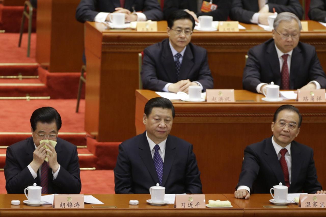 'China's President Hu Jintao (front row, L) wipes his face as China's Communist Party Chief Xi Jinping (front row, C) and China's Premier Wen Jiabao (front row, R), together with delegates attend t