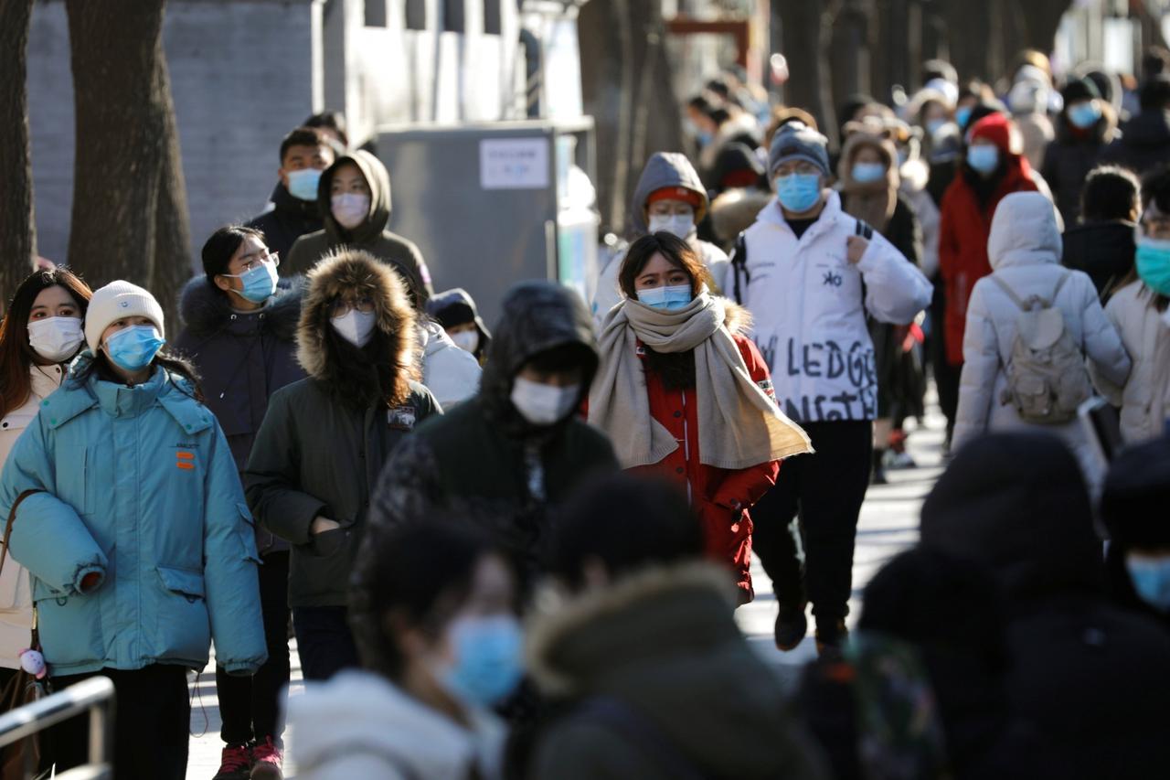 People wearing face masks following the coronavirus disease (COVID-19) outbreak walk along Nanluoguxiang alley