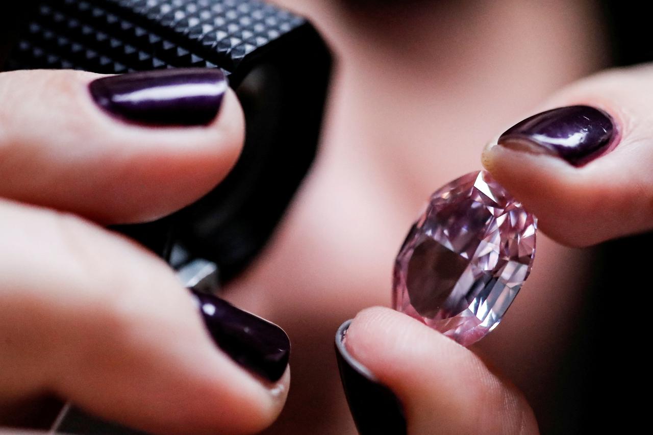 FILE PHOTO: An Alrosa employee holds a 14,83-carat pink diamond during an official presentation in Moscow