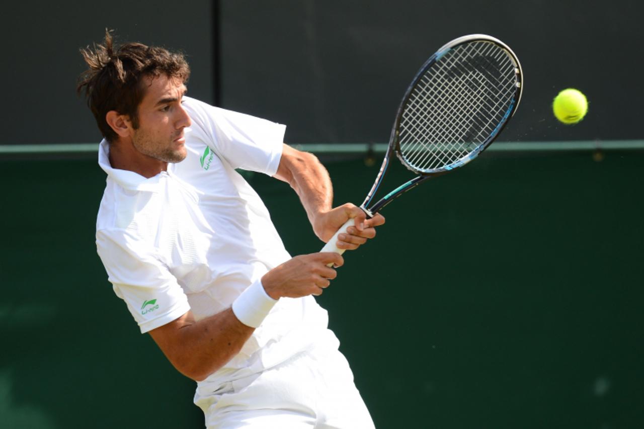 'Croatia\'s Marin Cilic plays a double-handed backhand shot during his third round men\'s singles match against US player Sam Querrey on day six of the 2012 Wimbledon Championships tennis tournament a
