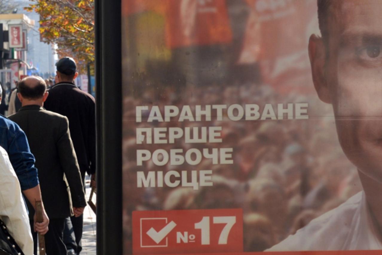 'People walk past a billboard of Ukrainian boxing champion Vitali Klitschko and his UDAR (punch) party on October 23, 2012 in the industrial city of Donetsk ahead of the October 28 parliamentary elect