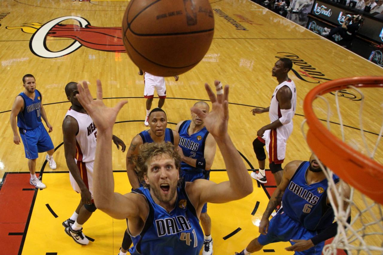 'Dallas Mavericks power forward Dirk Nowitzki looks for a rebound against the Miami Heat in the second half during Game 6 of the NBA Finals basketball series in Miami, June 12, 2011.   REUTERS/Ronald 
