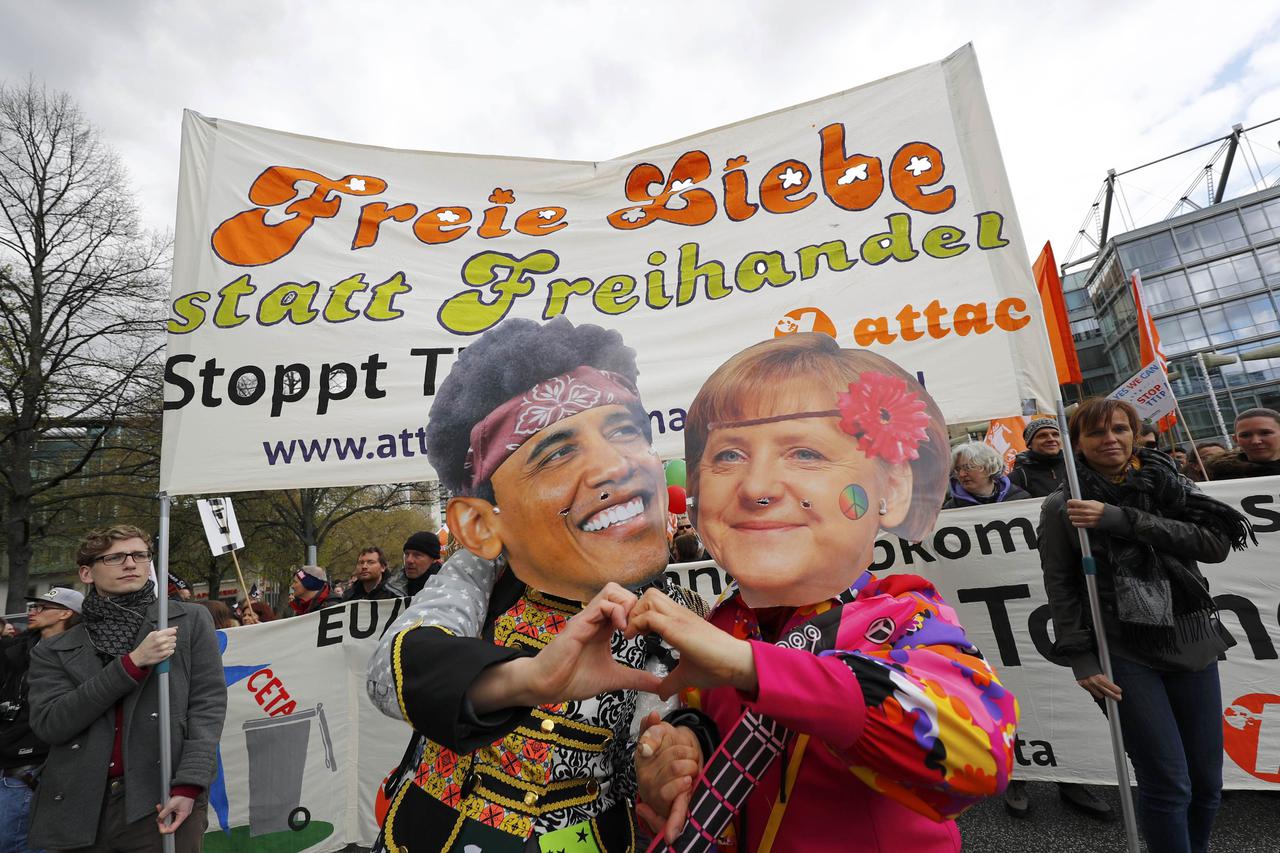 Protesters wearing masks depicting German Chancellor Angela Merkel and U.S. President Barack Obama as they demonstrate against Transatlantic Trade and Investment Partnership (TTIP) agreement ahead of Obama's visit in Hanover, Germany April 23, 2016.  REUT