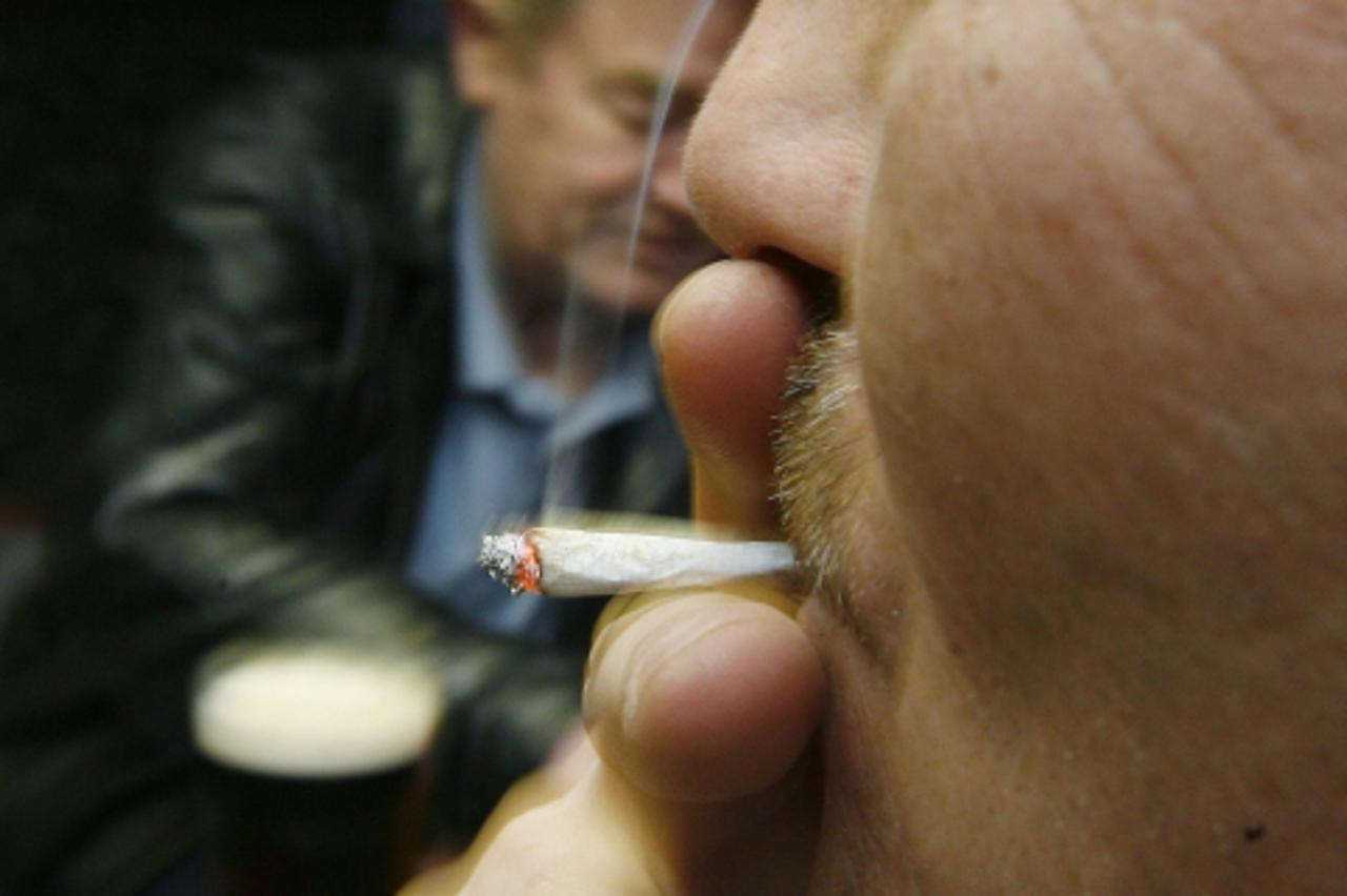 \'A man smokes a cigarette at Brambles Farm working mens club in Middlesbrough, northern England, in this June 30, 2007 file photo. A 2007 ban on smoking inside public places across the United Kingdom