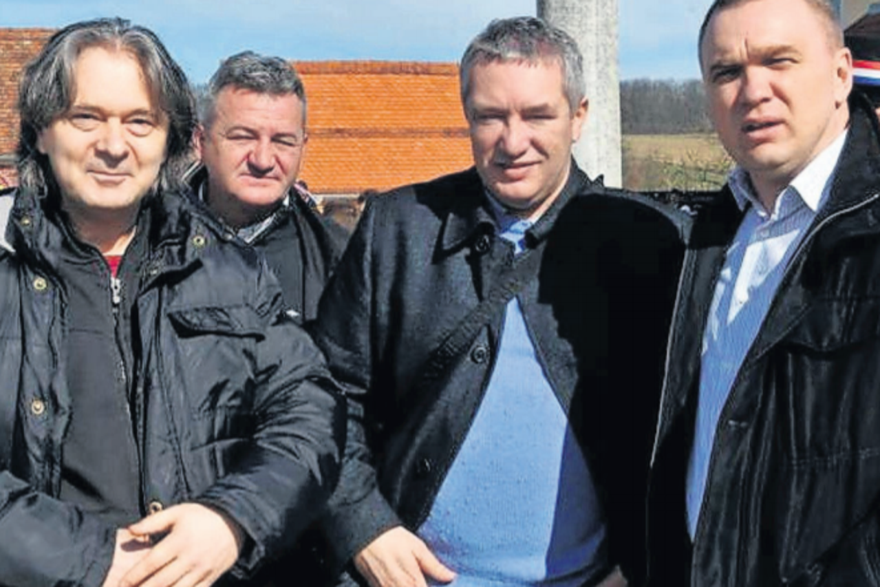 Dragan Kovačević u obiteljskom dvorištu u Brodskom Drenovcu 2014. s tamburašem Stankom Šarićem (lijevo) i dožupanom slavonsko-požeškim Vedranom Neferovićem (desno)
