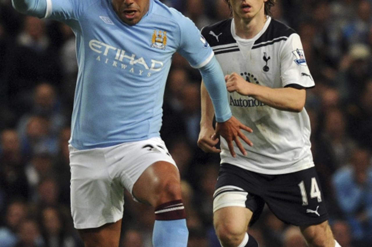 \'Manchester City\'s  Carlos Tevez (L) runs clear of Tottenham Hotspur\'s Luka Modric during their English Premier League soccer match in Manchester, northern England May 10, 2011. REUTERS/Nigel Roddi