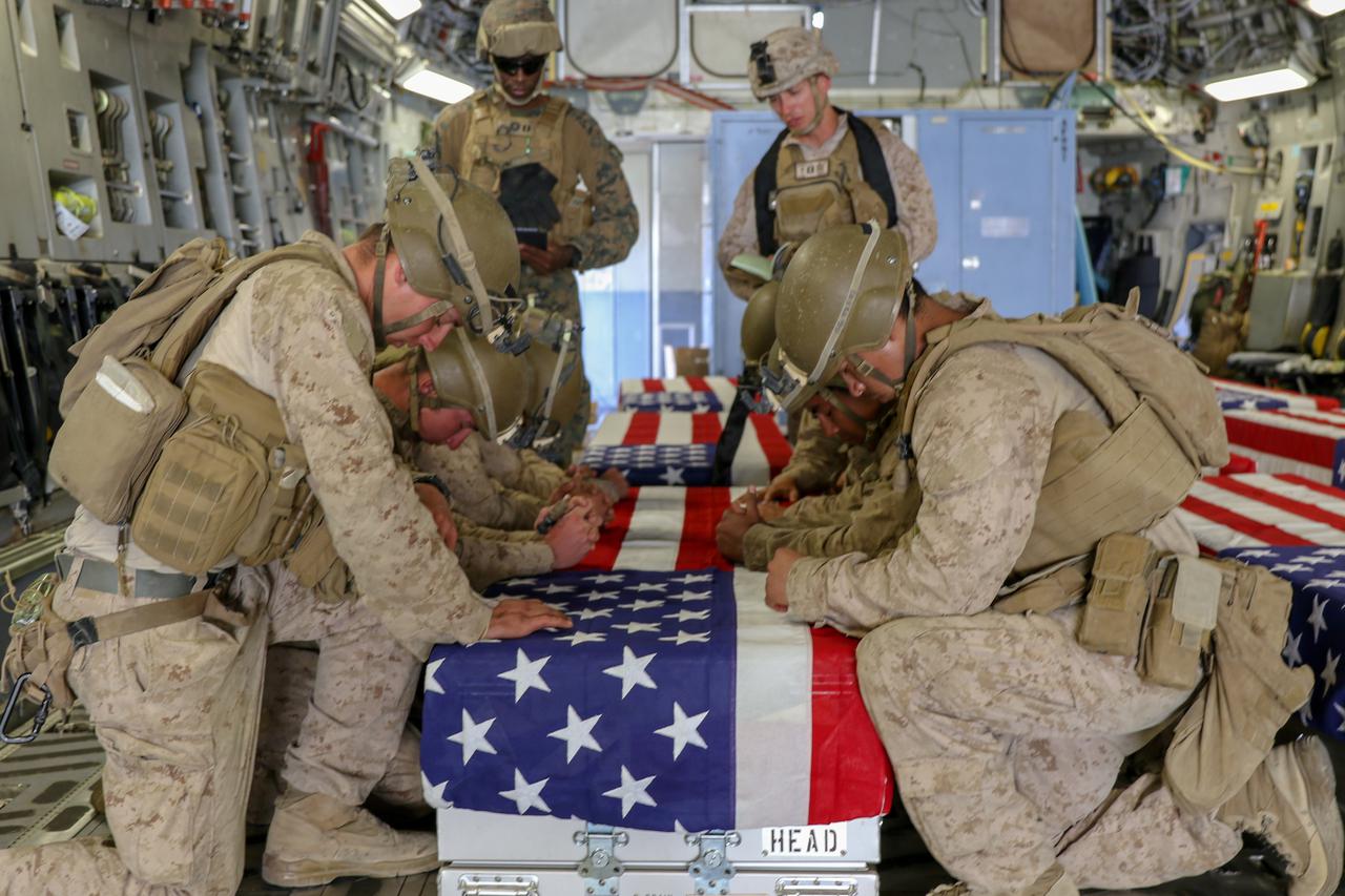U.S. Marines honor their fallen service members killed in action during a ramp ceremony in Kabul