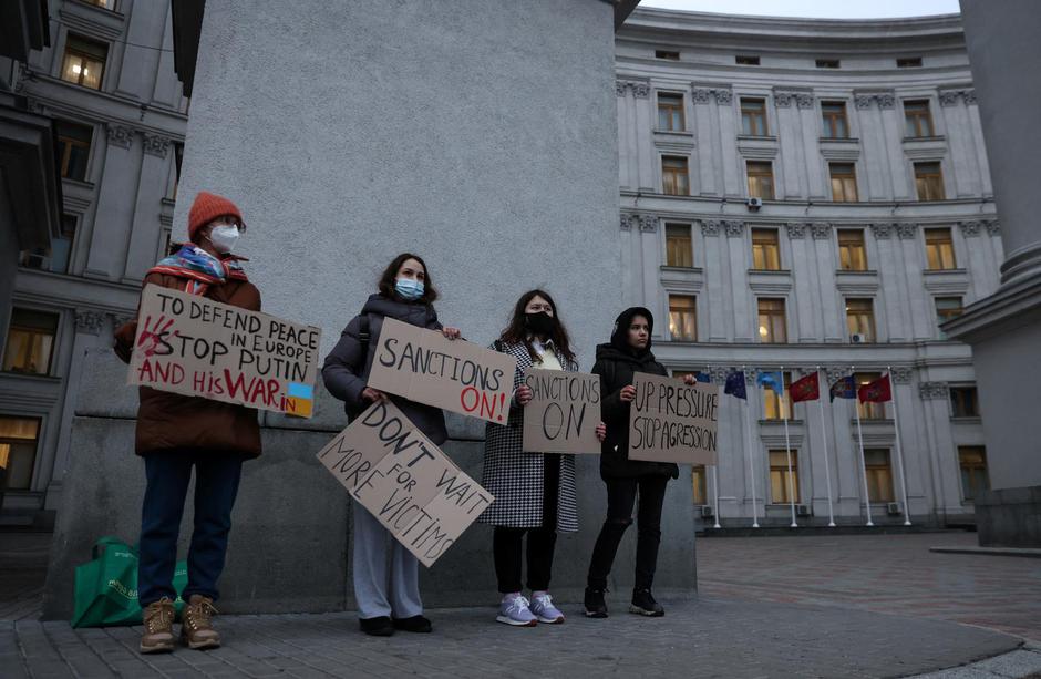 Activists hold banners in front the Ukrainian Foreign Ministry as they demand European Union to improve additional sanctions against Russia, in Kyiv