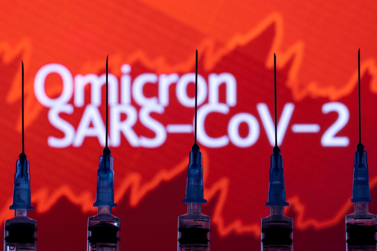 FILE PHOTO: Syringes with needles are seen in front of a displayed stock graph and words "Omicron SARS-CoV-2" in this illustration taken