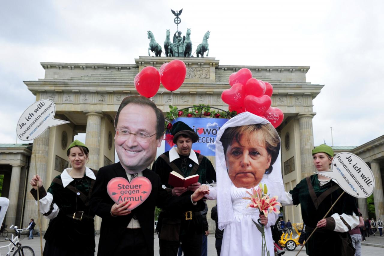'Activists wear masks featuring German chancellor Angela Merkel (2nd R) and incoming French socialist president Francois Hollande (2nd L) as they perform a fake marriage in front of the Brandenburg Ga