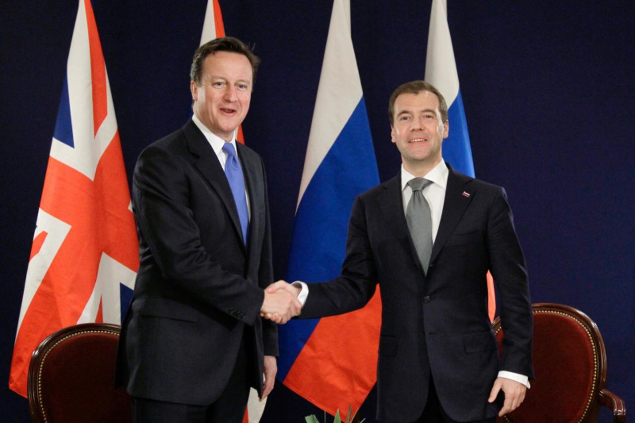 \'Russian President Dmitry Medvedev (R) and British Prime Minister David Cameron shake hands during their bilateral meeting on the sidelines of the G8 summit in Deauville, western France, on May 26, 2