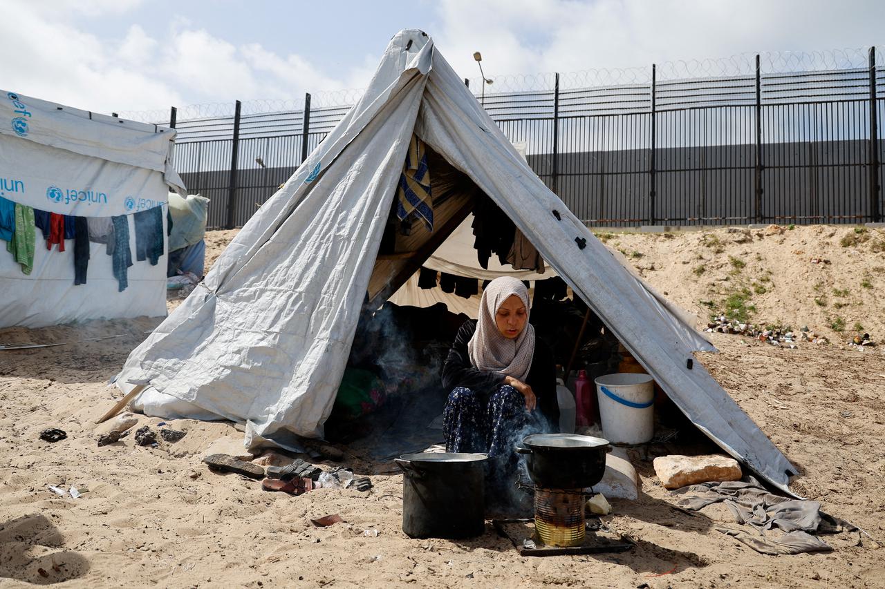 Displaced Palestinians, who fled their houses due to Israeli strikes, shelter at a tent camp, in Rafah