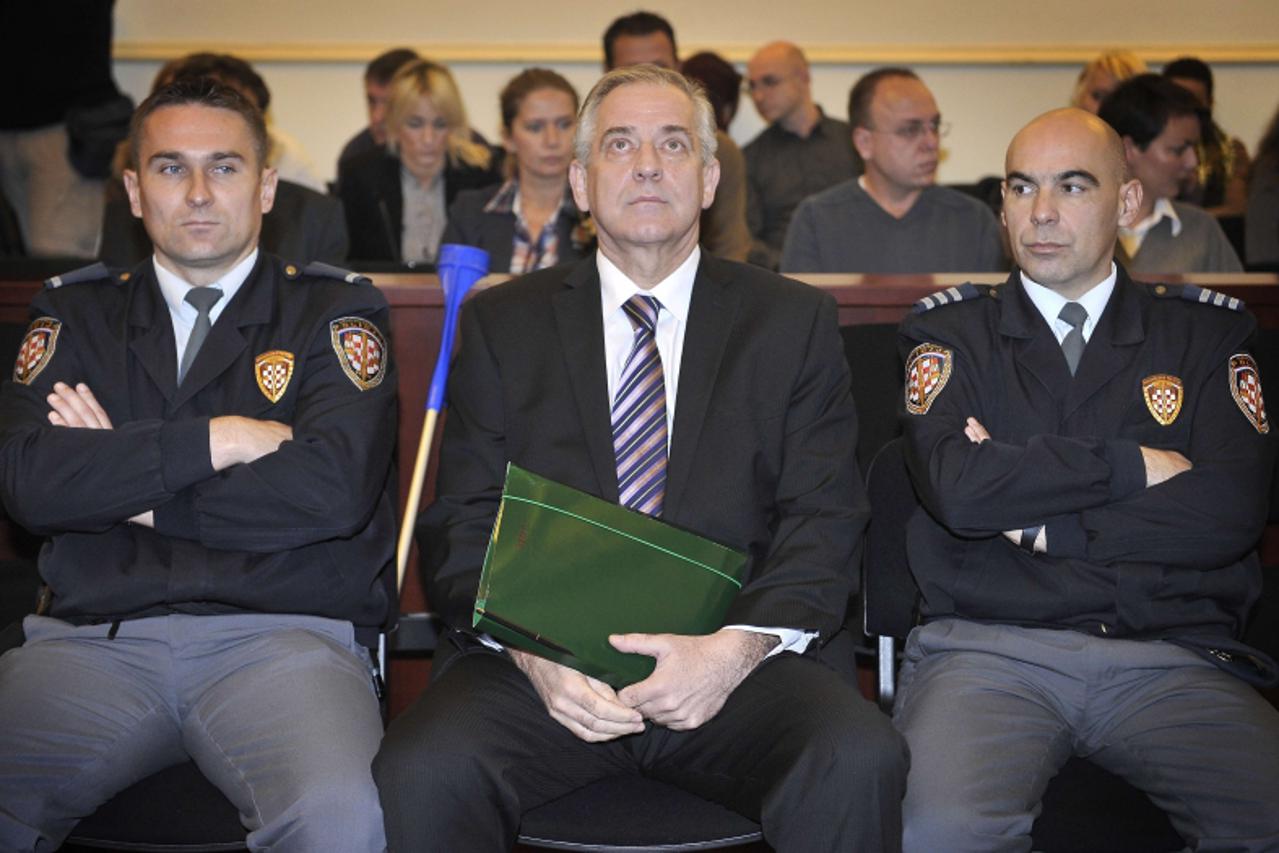\'Former Croatian Prime Minister Ivo Sanader (C), sits surrounded by court policemen at the beginning of his trial in Zagreb, on November 3, 2011. The corruption trial of former Croatian prime ministe