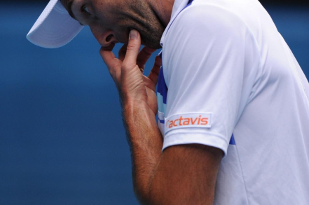 'Ivo Karlovic of Croatia reacts during his men\'s singles match against Roger Federer of Switzerland on the fifth day of the Australian Open tennis tournament in Melbourne on January 20, 2012.   AFP P