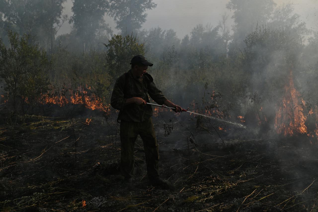 FILE PHOTO: Specialists put out a forest fire in Omsk Region