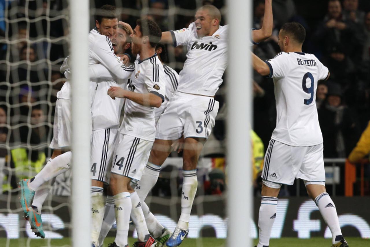 'Real Madrid\'s Mesut Ozil (L) celebrates his goal against Atletico Madrid with his teammates during their Spanish first division soccer match at Santiago Bernabeu stadium in Madrid December 1, 2012. 